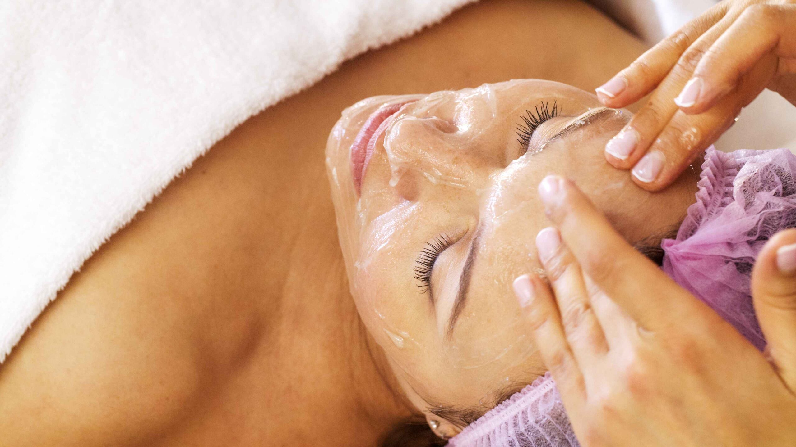Professional-grade skincare products and aesthetic facial tools set on a treatment table at Pōk Aesthetic Bar in Coral Gables.
