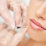 An aesthetic provider evaluating lip symmetry and volume during a facial consultation in Coral Gables