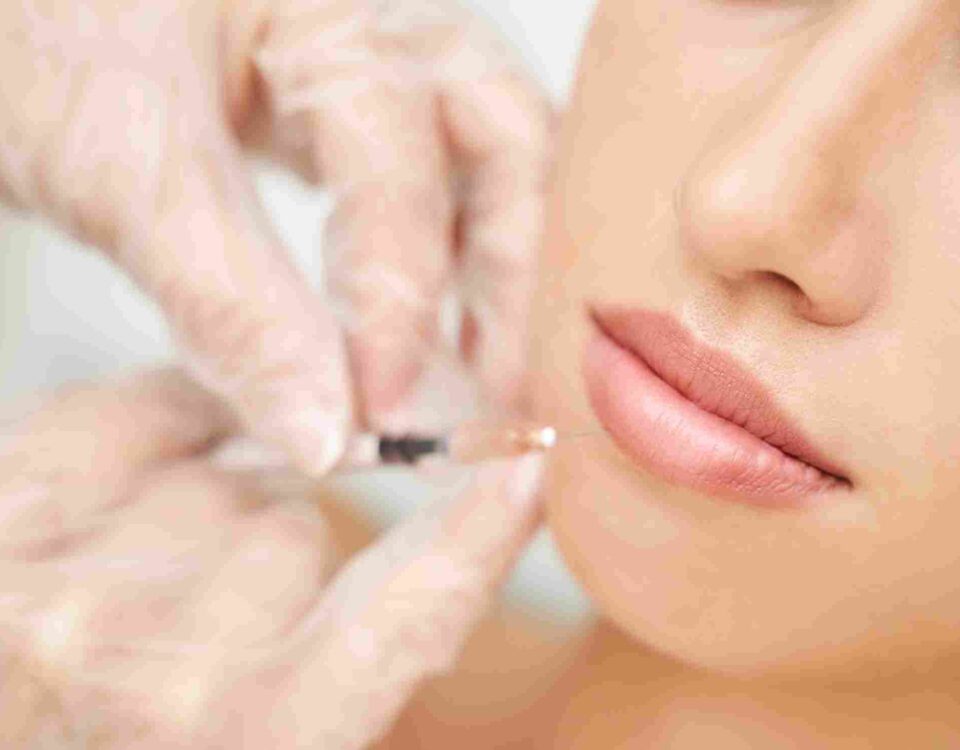 An aesthetic provider evaluating lip symmetry and volume during a facial consultation in Coral Gables