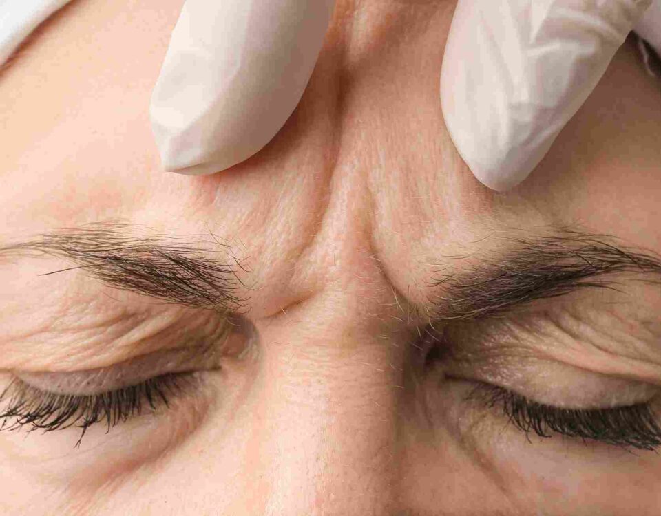 An aesthetic provider performing a detailed facial evaluation for a Daxxify treatment in Coral Gables