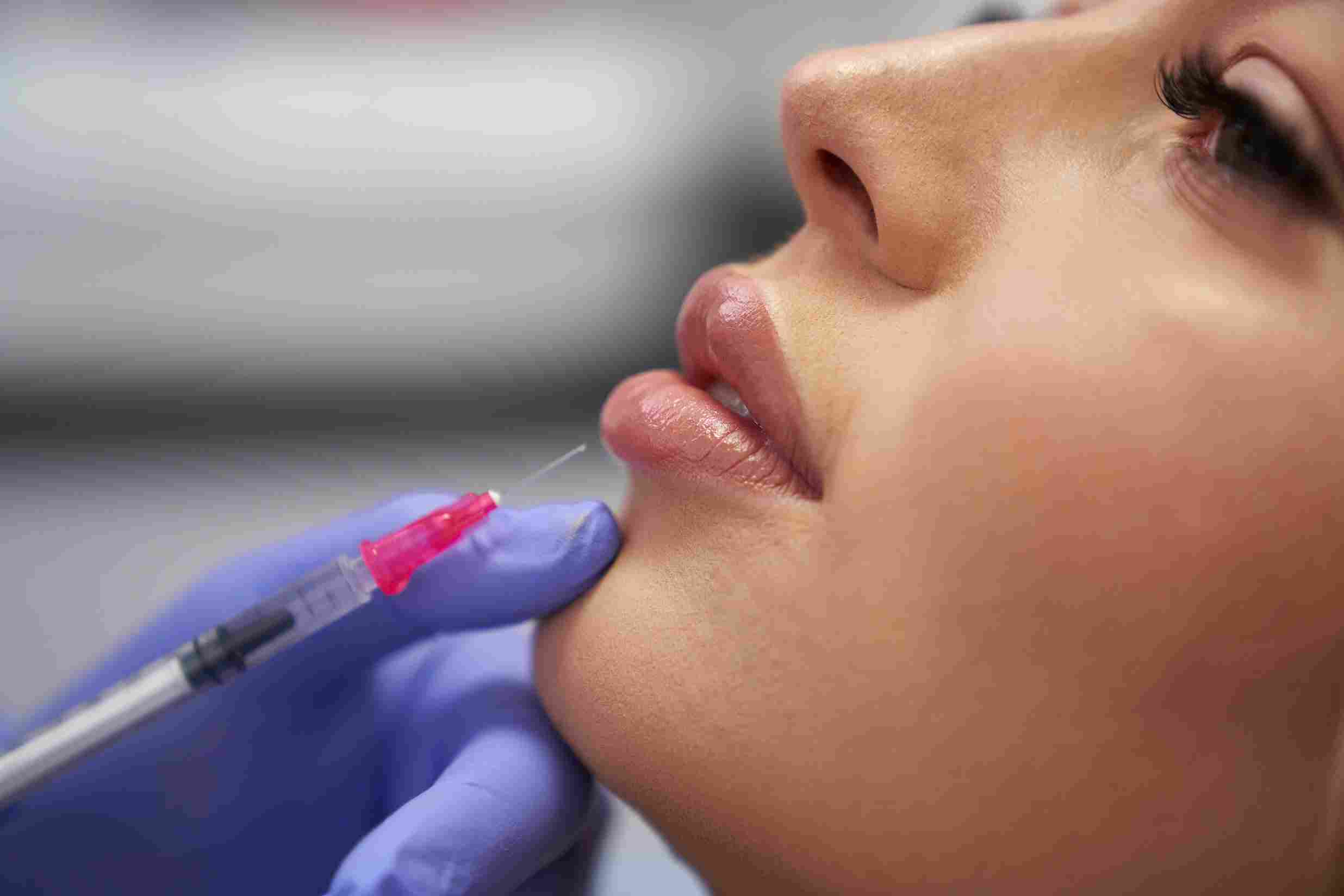 An aesthetic provider examining lip tissue during a personalized consultation in Coral Gables.