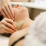 A clinical provider performing a personalized skin assessment before a facial service in Coral Gables