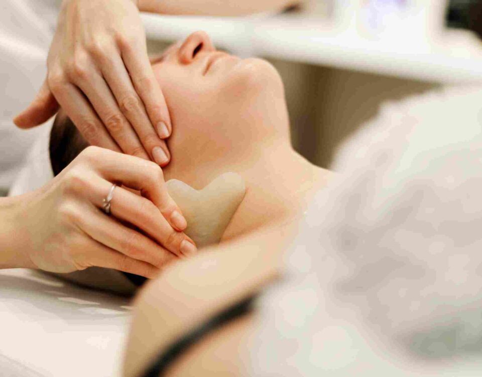 A clinical provider performing a personalized skin assessment before a facial service in Coral Gables
